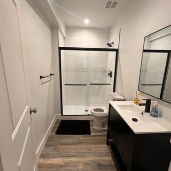 Redux Remodeling - a bathroom with a shower, toilet, and sink - General Contractors Near Me
