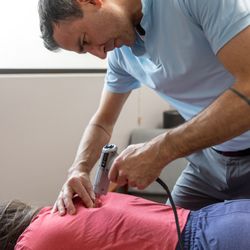 Inner Gate Health & Wellness - Dr Michael VanSooy performing a chiropractic adjustment with an activator.