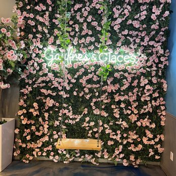 Gaufres & Glaces - a wall of flowers with a bench in front of it - Ice Cream & Frozen Yogurt Near Me - Laval, Quebec