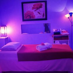 New Day Spa - Private massage room with calming lighting, clean linens, and a peaceful atmosphere for a relaxing body massage session.