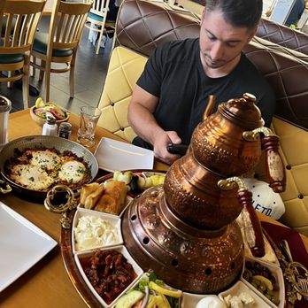 Rayoog Cafe - a man sitting at a table with food - Breakfast & Brunch Near Me - Gilbert, Arizona Rayoog Cafe - a man sitting at a table with food - Breakfast & Brunch Near Me - Gilbert, Arizona