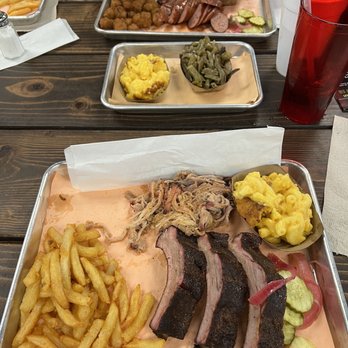 Big D's BBQ Branson - Ribs, pulled pork, mac and cheese, and fries. - A meal tray with barbecue ribs, pulled pork, French fries, macaroni and cheese, and pickles, served at a restaurant. - Barbeque Near Me - Branson, Missouri