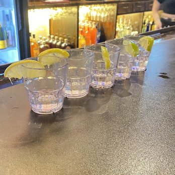 Two Bucks - a row of shot glasses on a bar - Cocktail Bars Near Me - Austin, Texas