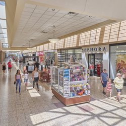 Eastland Mall - Shoppers walk through Eastland Mall past Sephora and kiosks toward Macy's.