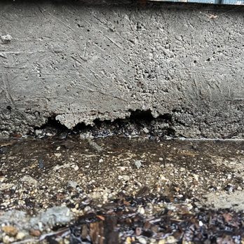 Foundation Builders - Holes in foundation wall + ground level concrete was poured at a slope towards the garage - traps water and funnels it straight in - Foundation Repair Near Me - North Hollywood, California