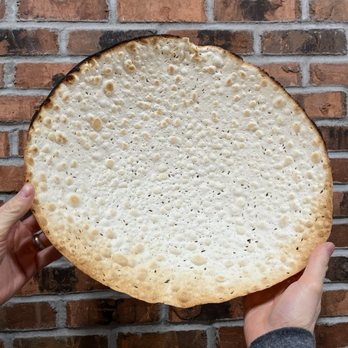 King David Bakery - a person holding up a large piece of bread - Bakeries Near Me - Queens, New York King David Bakery - a person holding up a large piece of bread - Bakeries Near Me - Queens, New York