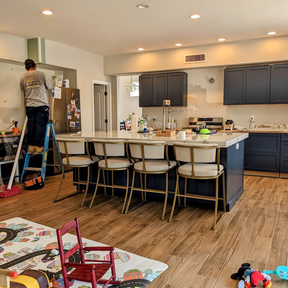 White Builder - a man standing on a ladder in a kitchen - General Contractors Near Me - Scottsdale, Arizona White Builder - a man standing on a ladder in a kitchen - General Contractors Near Me - Scottsdale, Arizona