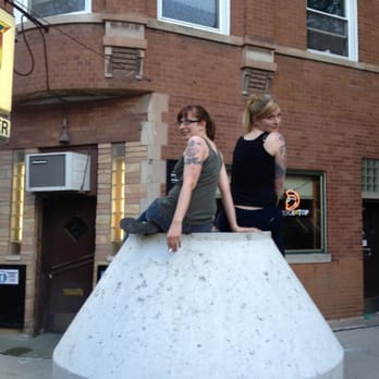 The Corner Bar - two women sitting on a concrete block - Dive Bars Near Me - Chicago, Illinois