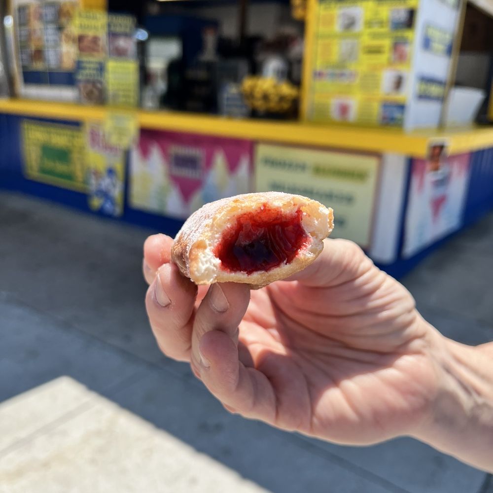 Madsen Donuts - a hand holding a half eaten donut - Donuts Near Me - Geneva, Ohio