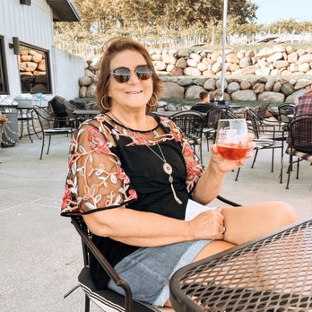Madison County Winery - a woman holding a glass of wine - Wine Tasting Room Near Me - Saint Charles, Iowa