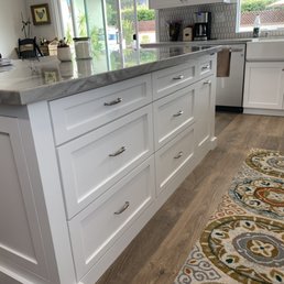 a kitchen with white cabinets and marble countertops a kitchen with white cabinets and marble countertops