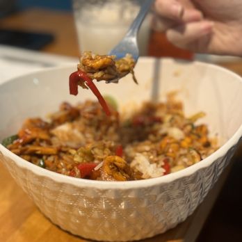 The Globe - a person holding a fork over a bowl of food - Asian Fusion Near Me - Madison, Wisconsin