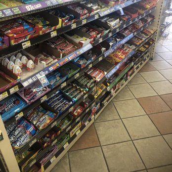 ampm - a display of candy - Candy and chocolate bars are displayed on shelves in a convenience store aisle, with promotional signs and price tags visible. - Convenience Stores Near Me - Turlock, California