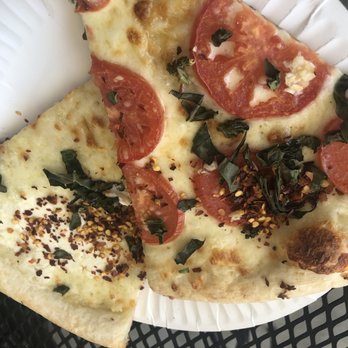 Flippin' Pizza - Whitestone and tomato basil. I hid one slice underneath to conceal the bite I took! Both delish! - Pizza Near Me - Vista, California Flippin' Pizza - Whitestone and tomato basil. I hid one slice underneath to conceal the bite I took! Both delish! - Pizza Near Me - Vista, California