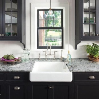 Top Stone - a kitchen with black cabinets and a white sink - Countertop Installation Near Me - Temple, Texas