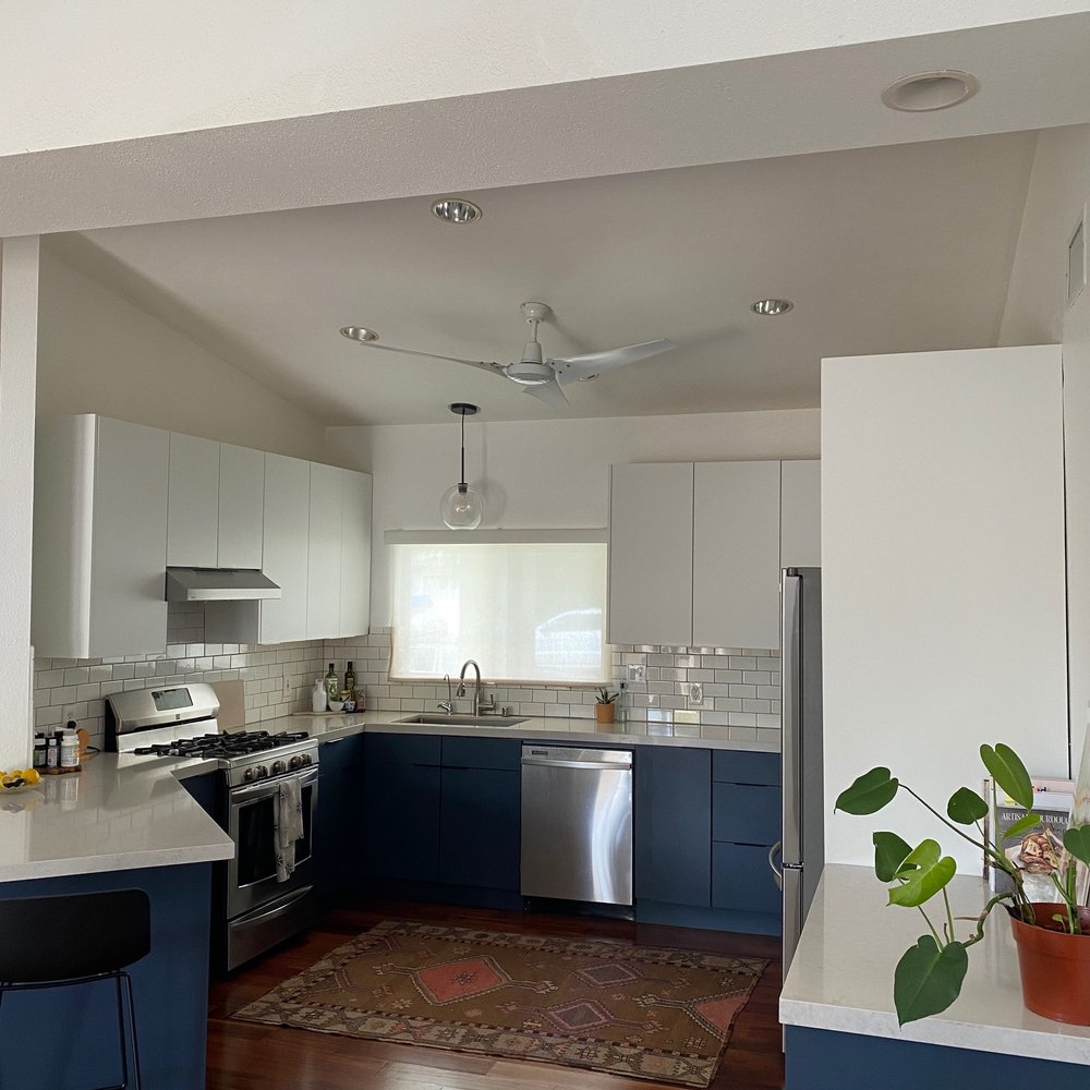 a kitchen with blue cabinets and white countertops a kitchen with blue cabinets and white countertops