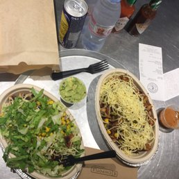 Chicken burrito bowls; one with guac and one with salad dressing. Chicken burrito bowls; one with guac and one with salad dressing.