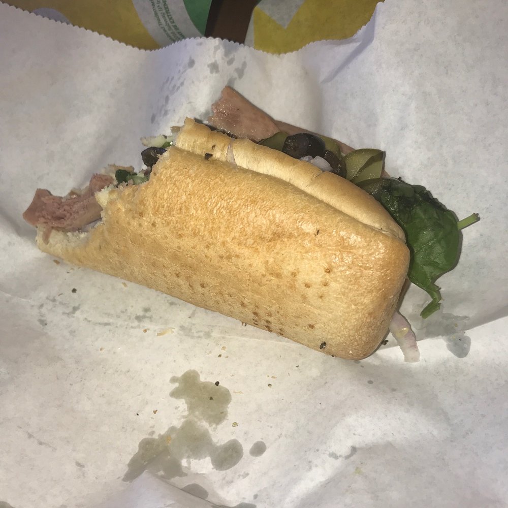 a half eaten sandwich in a wrapper a half eaten sandwich in a wrapper