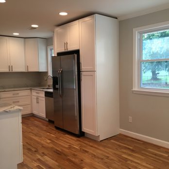 Marte Construction - a kitchen with white cabinets and stainless steel appliances - General Contractors Near Me