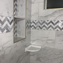 Marble tile, chevron decorative tile with gold schluter  trim. I LOVE the pop of gold that breaks up the gray/white tones