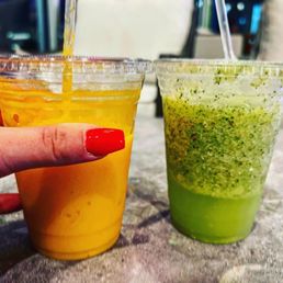 a woman's hand holding a plastic cup of juice a woman's hand holding a plastic cup of juice