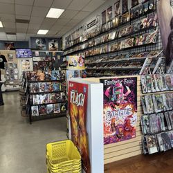 The Comic Den - Interior store - new comics on the wall, trades on the wire racks