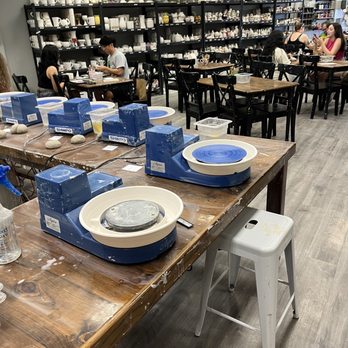 Quiggly's Clayhouse - Pottery wheels, and tables and items along the wall you can see the items you can buy and paint - Paint-Your-Own Pottery Near Me - Richardson, Texas Quiggly's Clayhouse - Pottery wheels, and tables and items along the wall you can see the items you can buy and paint - Paint-Your-Own Pottery Near Me - Richardson, Texas