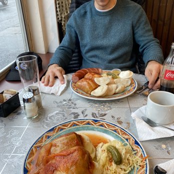 Ukrainian Village - a man sitting at a table with a plate of food - Ukrainian Near Me - Vancouver, British Columbia Ukrainian Village - a man sitting at a table with a plate of food - Ukrainian Near Me - Vancouver, British Columbia