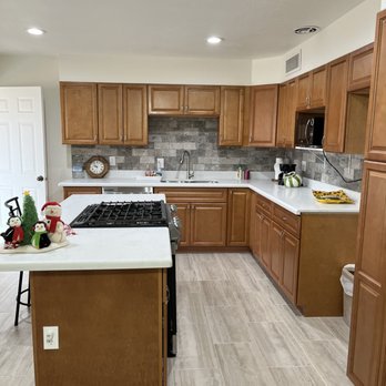 Acuity Builders & Construction - a kitchen with wood cabinets and white countertops - Damage Restoration Near Me - Phoenix, Arizona