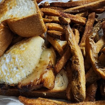 Doragon Eatery - Ultimate Breakfast Sando - A breakfast sandwich featuring a fried egg, melted cheese, and toasted bread, accompanied by a large portion of French fries. - Ramen Near Me - Ashland, Massachusetts
