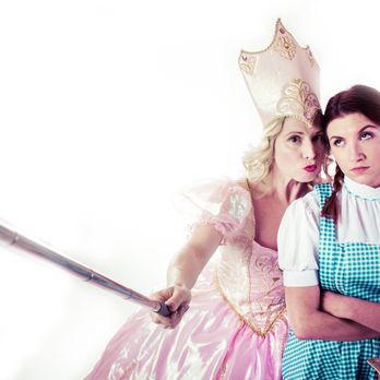 Without A Cue Productions - two women dressed in costumes - Dinner Theater Near Me