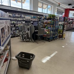 Walgreens - An empty basket sitting in the middle of the store (trash is next to it)