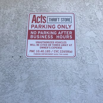 ACTS Thrift Store - Parking sign - A rectangular sign is mounted on a textured, off-white wall. The sign displays parking instructions for ACTS Thrift Store, indicating parking is only allowed during business hours and unauthorized vehicles will be cited or towed at the owner's expense. The sign includes contact information for parking enforcement and legal references. The wall has a rough, stucco-like surface with visible small holes and irregularities. - Thrift Stores Near Me - Pasadena, California