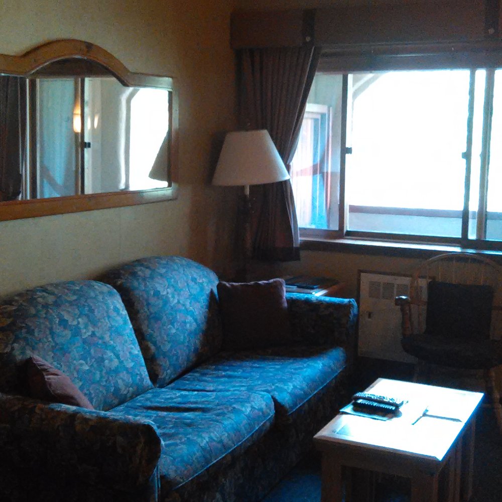 Olympic Village Inn - sofa bed in living room with balcony in background - Hotels Near Me - Olympic Valley, California