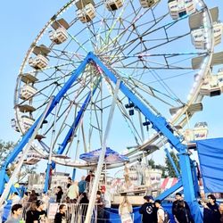 City of San Dimas - Ferris wheel glowing with colorful lights and long lines of excited guests enjoying one of the most iconic attractions at carnival event