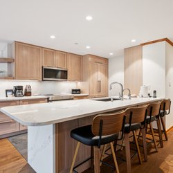Vail Spa Condominiums - The kitchen with a large island and stools for seating at a condo at Vail Spa Condominiums