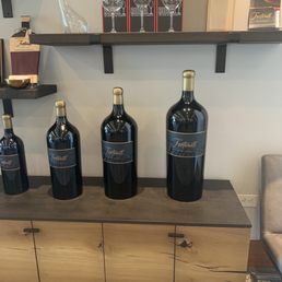 three bottles of wine on a shelf three bottles of wine on a shelf