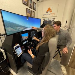Aviator NYC - A student pilot practices takeoff and landing on Aviator.NYC's flight simulator in Hudson Square, NYC, with an airline pilot instructor prov