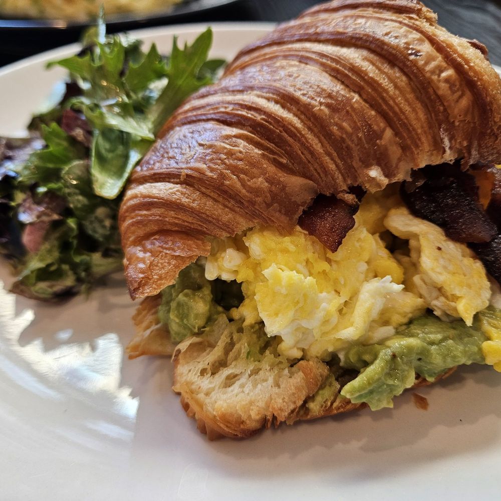 Croissant sandwhich with eggs, bacon and avocado