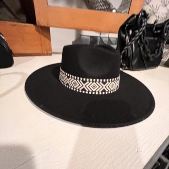 The Cypress House - a black hat on a white table - Florists Near Me - Rochelle, Illinois