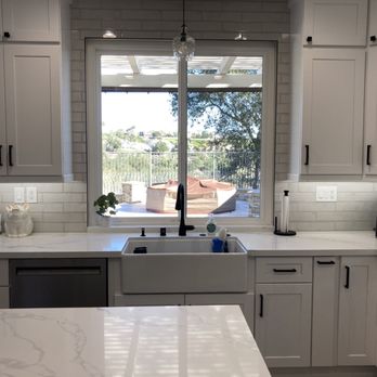 Johnny Ray Construction - a kitchen with white cabinets and a large window - General Contractors Near Me Johnny Ray Construction - a kitchen with white cabinets and a large window - General Contractors Near Me