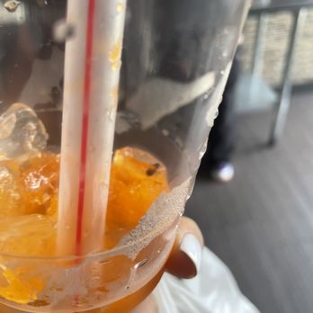 New China Mongolian Bbq - a hand holding a plastic cup filled with orange juice - Chinese Near Me - Los Angeles, California