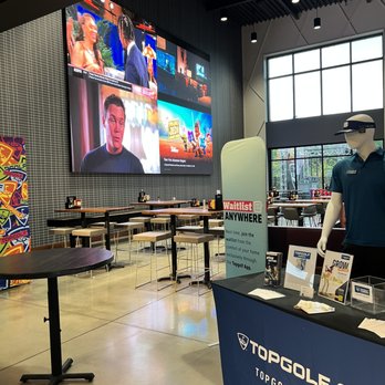 Topgolf - a man in a blue polo shirt standing in front of a table - American Near Me - Farragut, Tennessee Topgolf - a man in a blue polo shirt standing in front of a table - American Near Me - Farragut, Tennessee