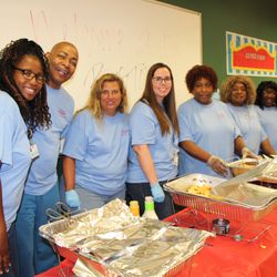 River Edge Behavioral Health - Staff serving food at an event pose for the camera.