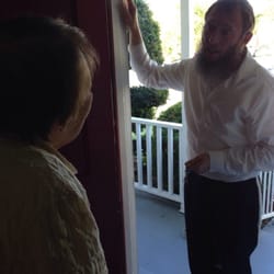 The Marina Shul - Rabbi Yoske places a brand new Kosher mezzuzah on a friend's door