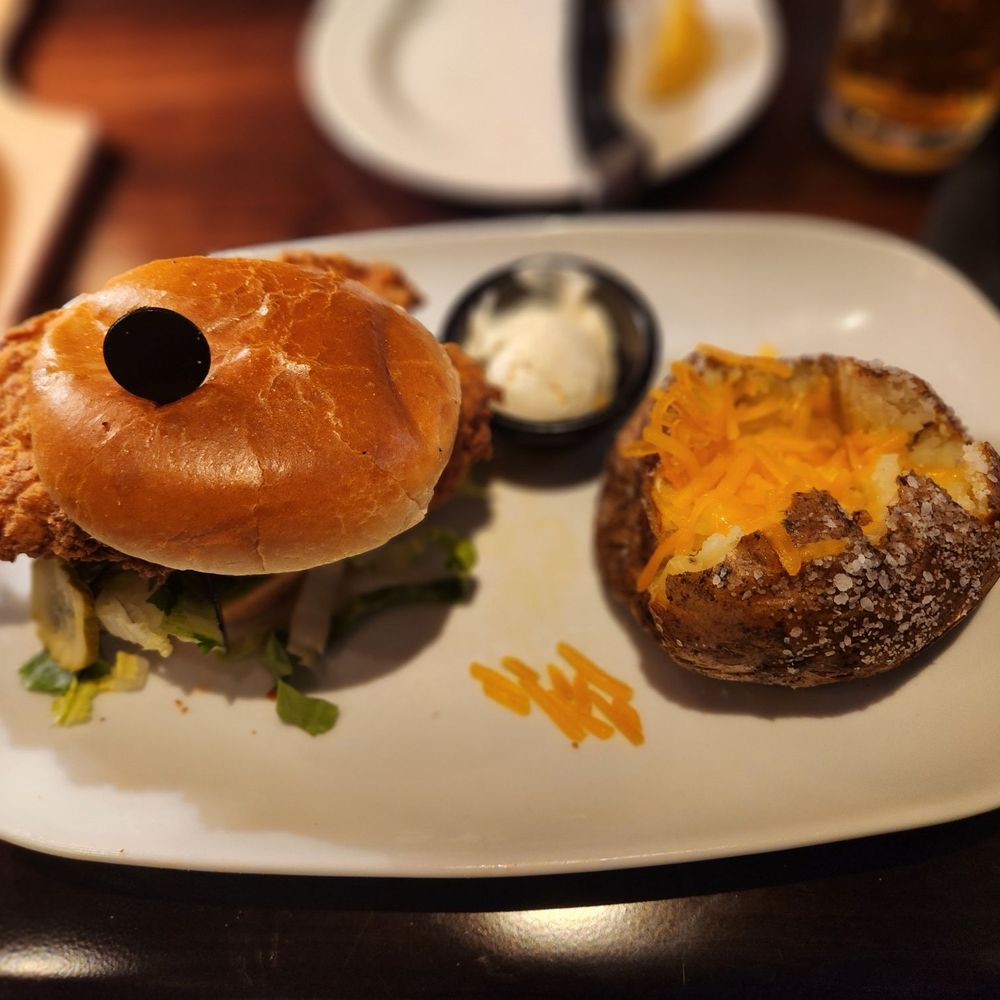 a chicken sandwich and a baked potato a chicken sandwich and a baked potato
