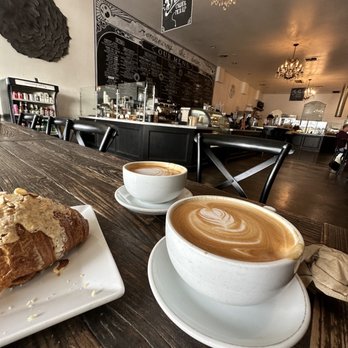 Romancing the Bean Cafe - View of coffee bar, menu and kitchen from the long table inside the shop. - Coffee & Tea Near Me - Burbank, California Romancing the Bean Cafe - View of coffee bar, menu and kitchen from the long table inside the shop. - Coffee & Tea Near Me - Burbank, California