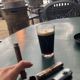 a glass of beer and a cigar on a table