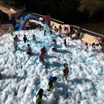 Foaming Shark Party - "A lively scene capturing kids and adults alike immersed in a sea of fluffy foam, with excited smiles and shark-themed. - Party Equipment Rentals Near Me Foaming Shark Party - "A lively scene capturing kids and adults alike immersed in a sea of fluffy foam, with excited smiles and shark-themed. - Party Equipment Rentals Near Me
