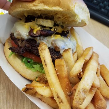 Burger Warrior - a hand holding a hamburger and french fries - Food Trucks Near Me
